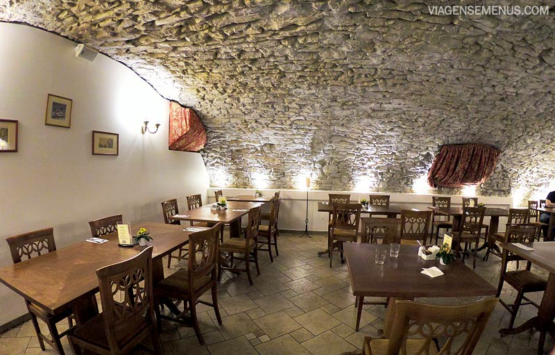 Hotel Leonardo - salão do café da manhã, teto oval e paredes de pedra, mesas e cadeiras de madeira