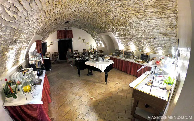 Hotel Leonardo - salão do café da manhã, teto oval e paredes de pedra, mesas com o buffet de café da manhã