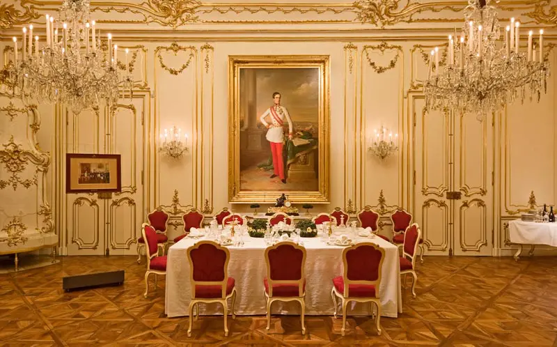 Palácio de Schonbrunn - apartamentos imperiais - sala de banquete com cadeiras vermelhas e mesa com toalha branca
