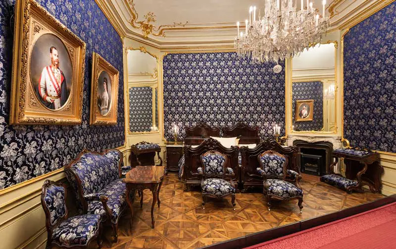 Palácio de Schonbrunn - apartamentos imperiais - sala com papel de parede igual ao estofado das cadeiras, azul escuro com ornamentos branco