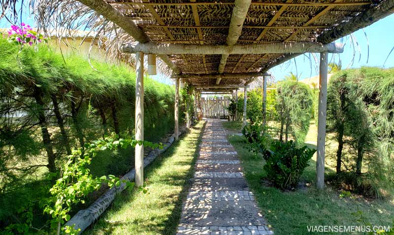 Hotel Vila Selvagem, Fortim, Ceará - um caminho com teto de palha, grama e plantas ao redor