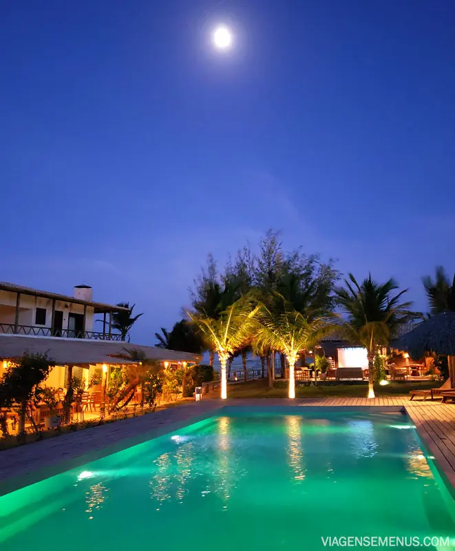 Hotel Vila Selvagem, Fortim, Ceará - piscina à noite iluminada no tom de verde, com a lua aparecendo