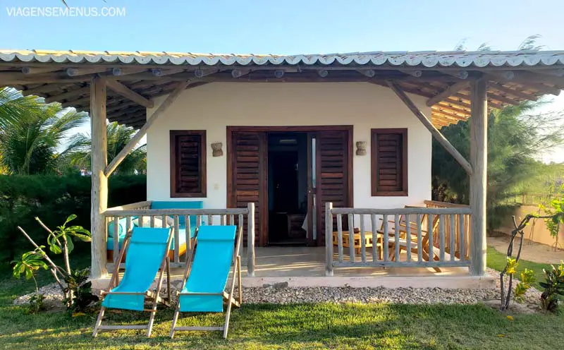 Hotel Vila Selvagem, Fortim, Ceará - imagem do bangalô, 2 cadeiras azul-tiffany na frente, portas de madeira e parede branca, teto de telhas