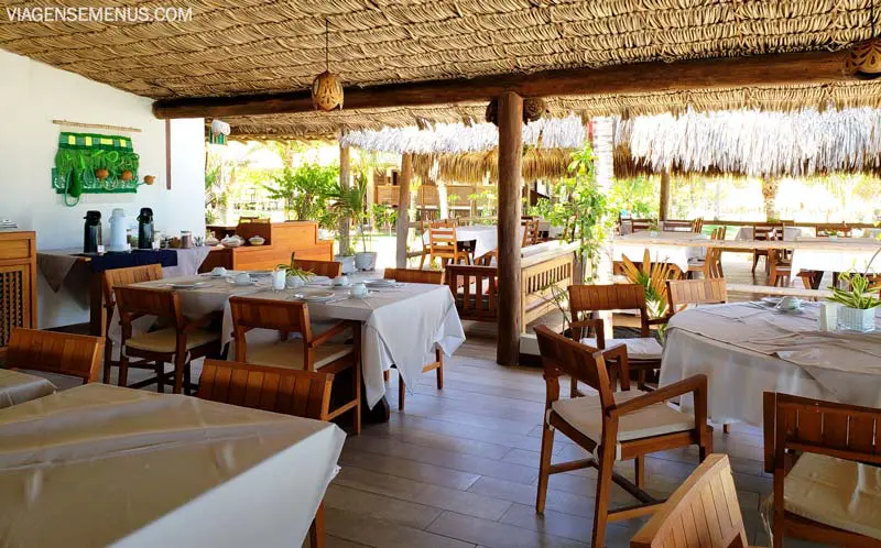 Hotel Vila Selvagem, Fortim, Ceará - mesas e cadeiras de madeira, mesas com toalhas brancas, teto de palhoça