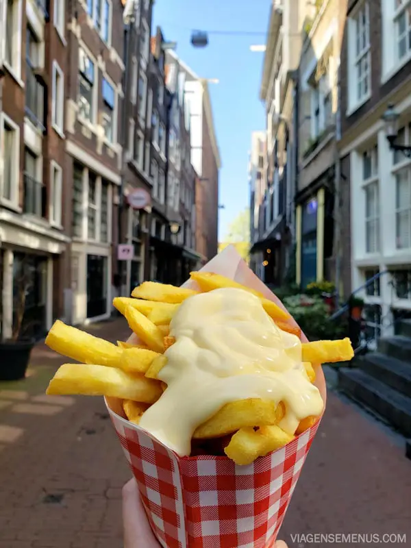 O que comer em Amsterdam - Patat - batata frita no cone com a cidade ao fundo