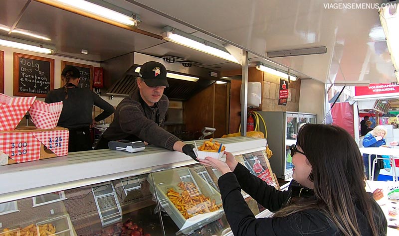 O que comer em Amsterdam - Patat - Livia pegando a batata frita do estande