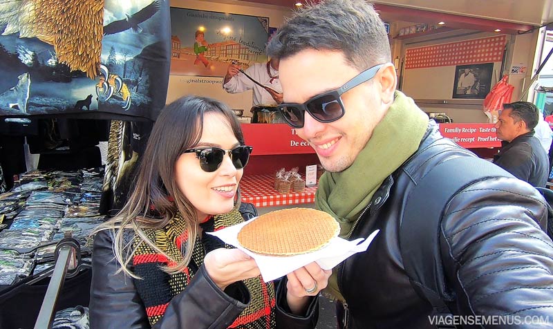 O que comer em Amsterdam - Livia e Samuel segurando um stroopwafel e olhando pra ele