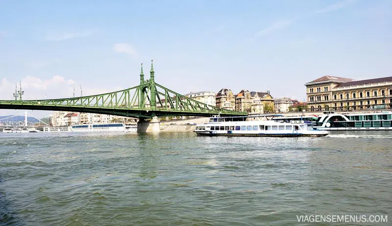 Passeio de barco em Budapeste - lado peste visto do rio, com a Ponte da Liberdade e barcos na mergem
