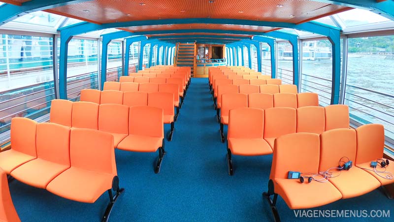 Passeio de barco em Budapeste - interior do barco da Legenda Cruises, com cadeiras laranjas e carpete azul