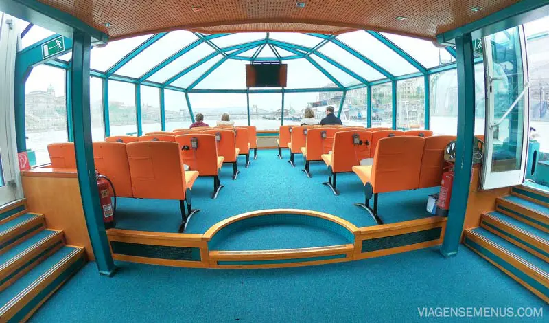 Passeio de barco em Budapeste - interior do barco da Legenda Cruises, com cadeiras laranjas e carpete azul