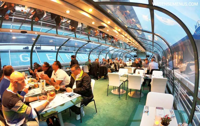 Passeio de barco em Budapeste - interior do barco de jantar da Legenda Cruises, com várias mesas de vidro e cadeiras brancas