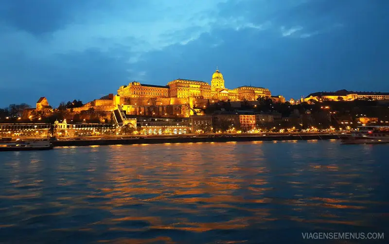 Passeio de barco noturno em Budapeste - Castelo de Buda visto do rio, iluminado de amarelo 