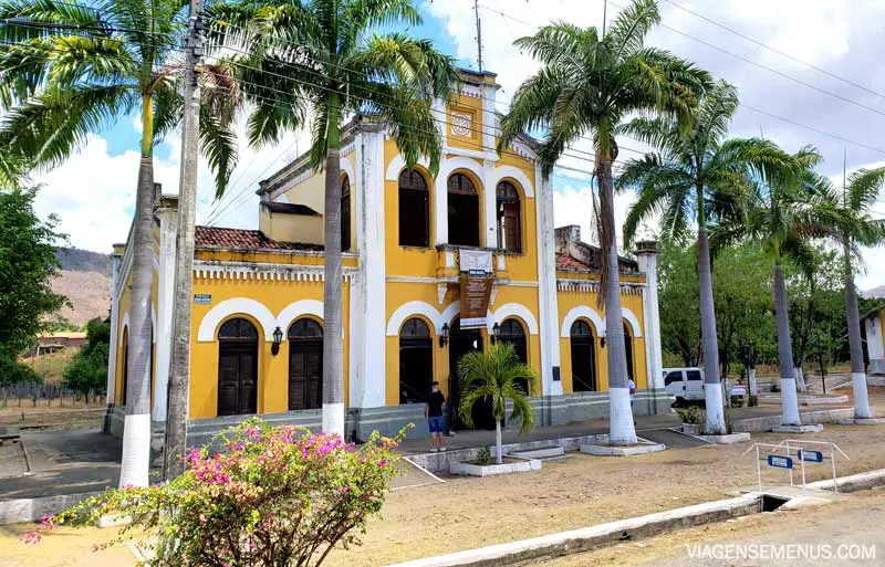 Rota Caminhos de História e Fé, Baturité, Ceará - estação ferroviária vista de fora, construção branca e amarela forte com palmeiras dos lados