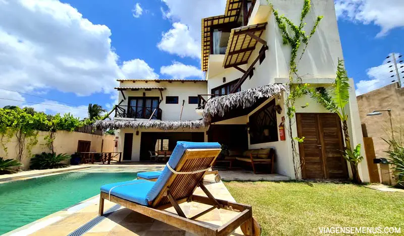 Vila Harmonia, Praia do Preá - imagem da casa vista da piscina, com uma espreguiçadeira de almofada azul.