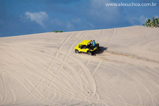 Buggy amarelo em cima de uma duna de areia branca - Cumbuco, Ceará