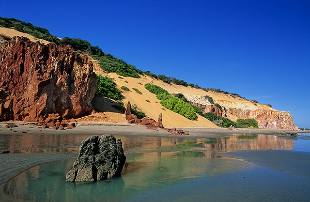 Praia de Ponta Grossa com dunas ao fundos, rochas e pedras na areia - Icapuí. o que fazer no Ceará