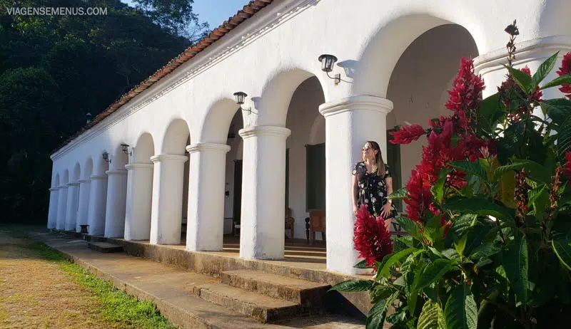 Imagem do casarão do Sítio São Luís, paredes brancas em arcos, plantas e flores de cor rosa forte - Pacoti, Maciço de Baturité, o que fazer no Ceará